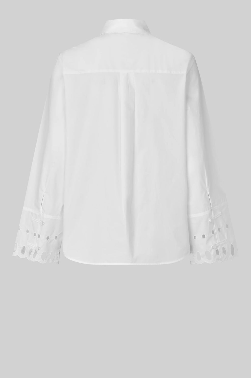 White shirt with cut-out details on the sleeves against a gray background