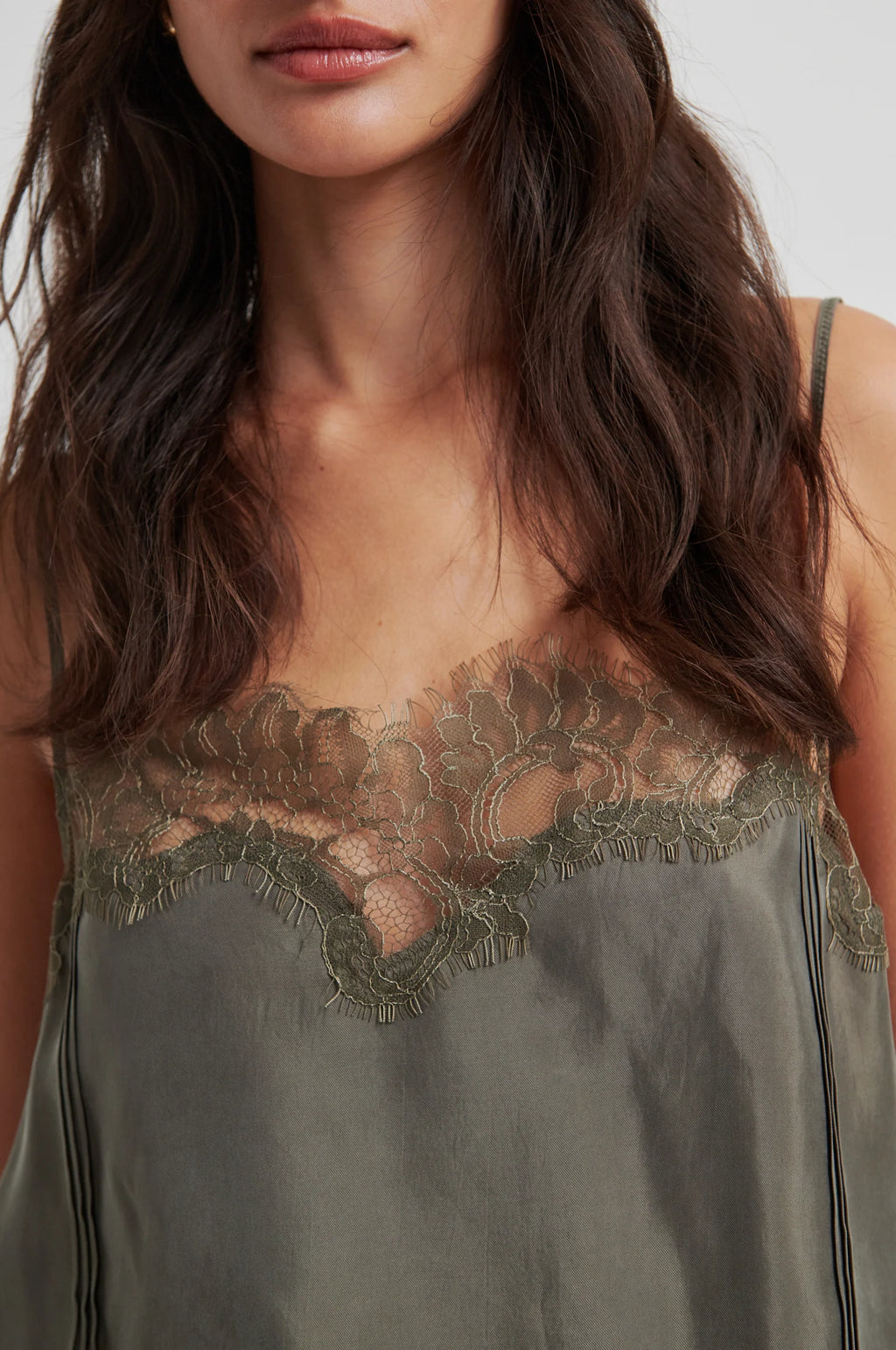 Woman wearing a green top with lace detailing