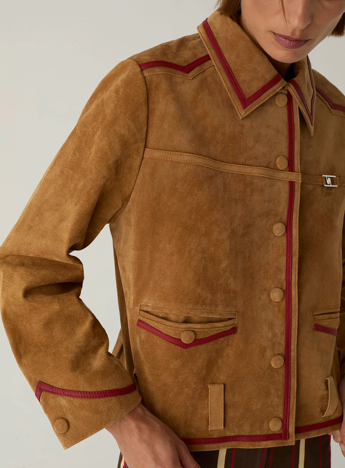 Front of the LAAGAM Aveline suede jacket: chest tape with metal logo, snap buttons and red-piped flap pockets.