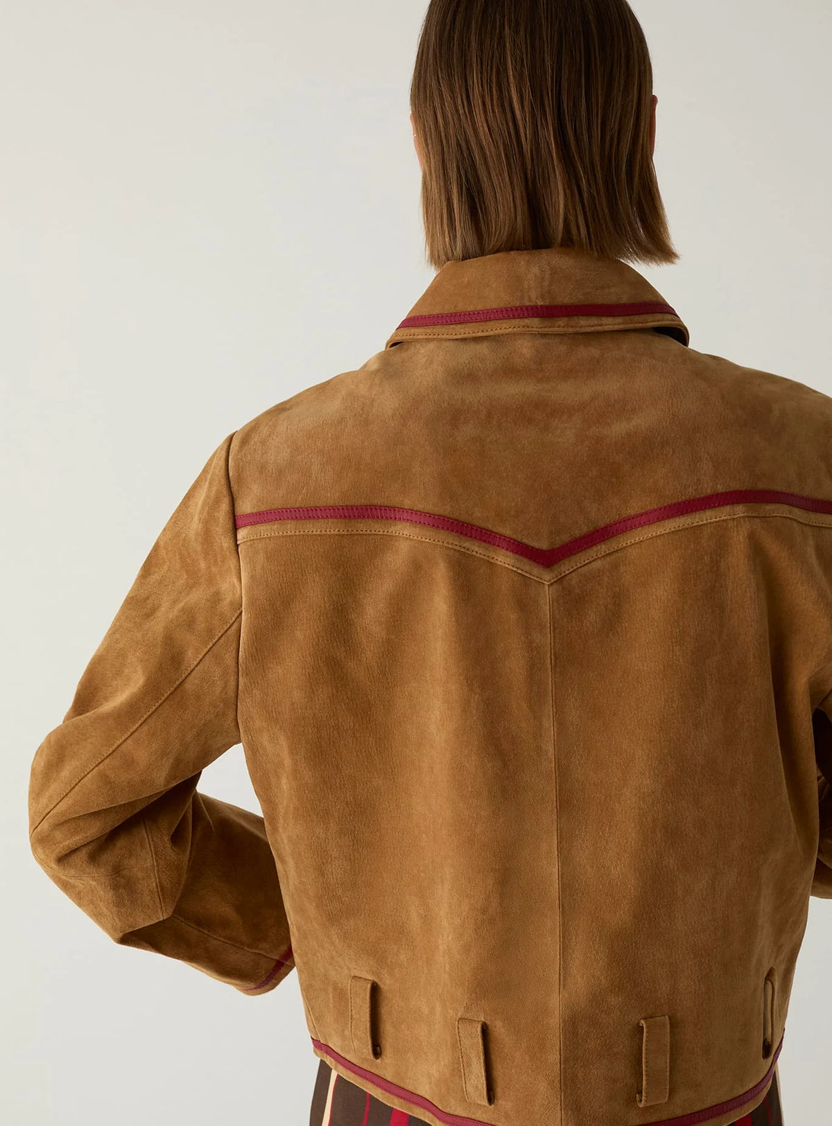 Back of the LAAGAM Aveline camel suede jacket, showing the chevron yoke in red napa piping and belt loops.